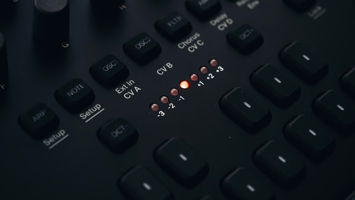 Detailed view of a dark electronic audio interface with knobs and buttons.